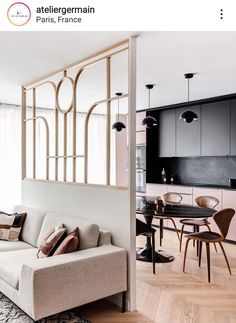 a living room filled with furniture next to a kitchen and dining room table on top of a hard wood floor