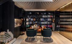 two people sitting at a table in the middle of a room with bookshelves