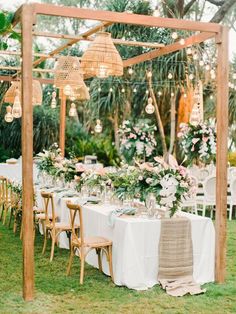 an outdoor dining area with tables, chairs and chandelier hanging from the ceiling