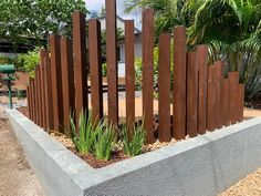 a wooden fence is in the middle of a planter filled with succulents