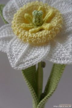 a crocheted white flower with yellow center