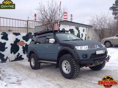 a grey four - doored suv parked in the snow