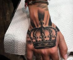 a hand with a crown tattoo on it