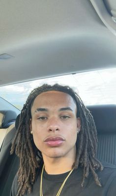 a man with dreadlocks sitting in a car