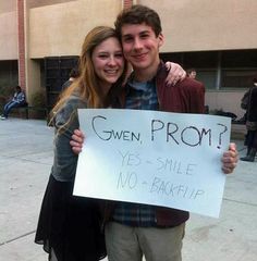 a man and woman holding a sign that says given prom? yes smile no - bake if