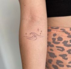 a woman's arm with a small wave tattoo on the left side of her right arm