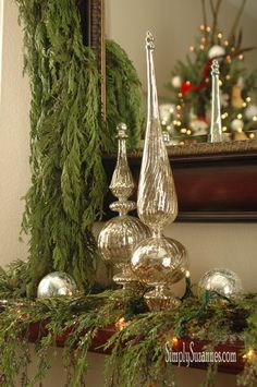 a mantle with christmas decorations on it and a mirror in the back ground behind it