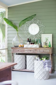 a table with some bottles and containers on it next to a plant in a vase