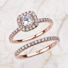 two rose gold wedding rings with diamonds in them on a white marble slabd surface