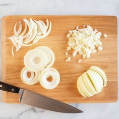 onions, onion and garlic on a cutting board next to a knife