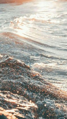 the sun shines on the water as it breaks through the waves in the ocean