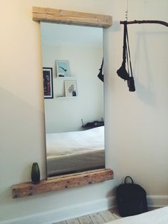 a mirror hanging on the wall next to a bed