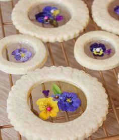 small cookies with edible flowers in them on a cooling rack