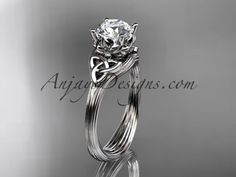 a white gold diamond engagement ring set with an intricate knot design on the band and center stone