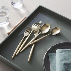 there are four spoons and two forks on the tray