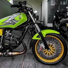 a green and yellow motorcycle parked in front of a building