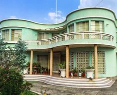 a large green building with lots of windows and balconies on the top floor