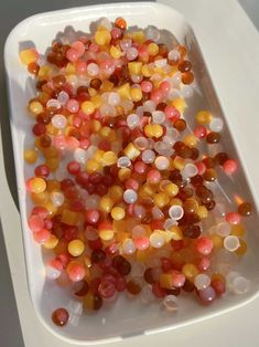 several different colored beads in a white container