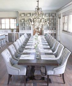 a dining room table with chairs and a chandelier hanging from the ceiling