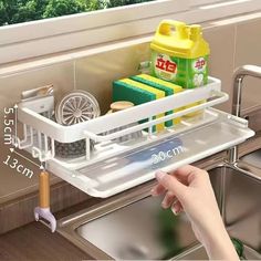 a kitchen sink that has some cleaning products in it and is holding a dish rack