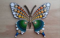 a colorful butterfly made out of beads on a wooden surface