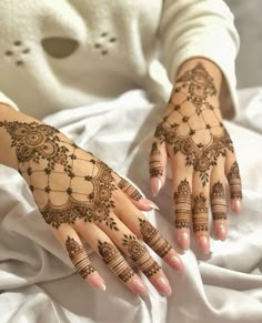 a woman's hands with henna tattoos on them