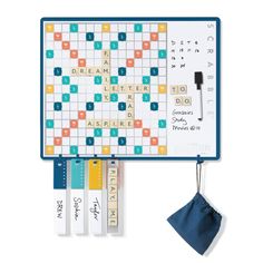 a scrabble board is hanging on the wall next to some pens and pencils