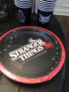 a table topped with plates and cups filled with drink on top of a black cloth covered table