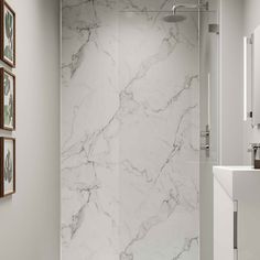 a white bathroom with marble walls and floor