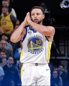 a basketball player holding his hand up in the air while standing next to an audience