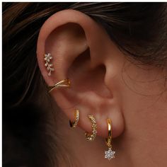 a woman wearing three different types of ear piercings