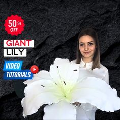 a woman holding a large white flower in front of a black background with the words giant lily on it