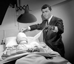 a black and white photo of a man in a hospital bed with an injured leg