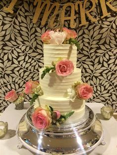 a three tiered cake with pink flowers on top