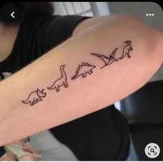 a person with a tattoo on their arm that has three dinosaurs in the same line