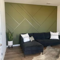 a living room filled with furniture and a large green wall mounted on the side of it