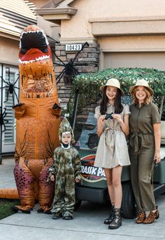 two women standing next to an inflatable dinosaur