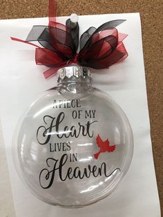 a glass ornament with a red and black bow on it that says, piece of my heart lives in heaven