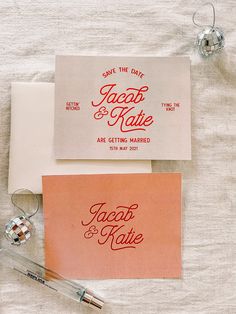 the wedding stationery is laid out on top of each other, including an envelope and pen