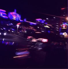 blurry photograph of neon signs in the city at night