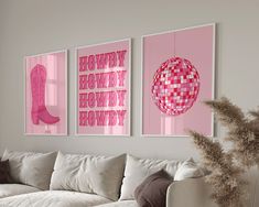 a living room with white couches and pink art hanging on the wall above them