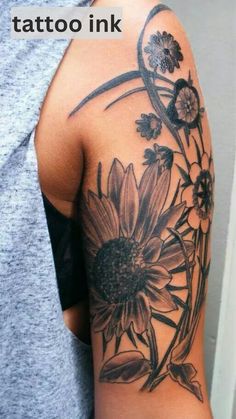 the back of a woman's arm with flowers on it and an arrow tattoo ink