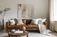 a living room filled with furniture and pillows on top of a wooden table next to a window