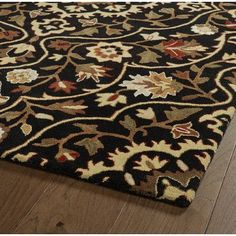 a black and gold rug on top of a wooden floor next to a wood floor