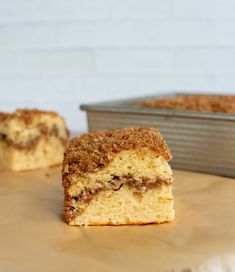 a piece of cake sitting on top of a wooden table next to a metal pan