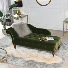 a green velvet chaise lounger in a living room with white carpet and gold accents