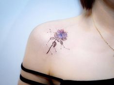 a woman's shoulder with a flower tattoo on the left side of her chest