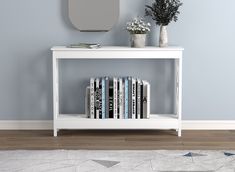 a white book shelf with books on it and a mirror in the corner behind it