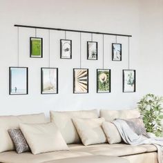 a living room filled with white furniture and pictures on the wall above it's headboard