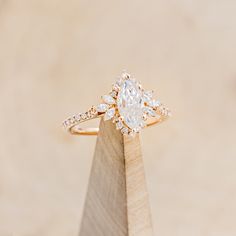 a diamond ring sitting on top of a wooden stand